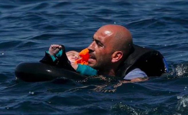 Turkish man tries to save his baby after boat capsizes western coast off Turkey.