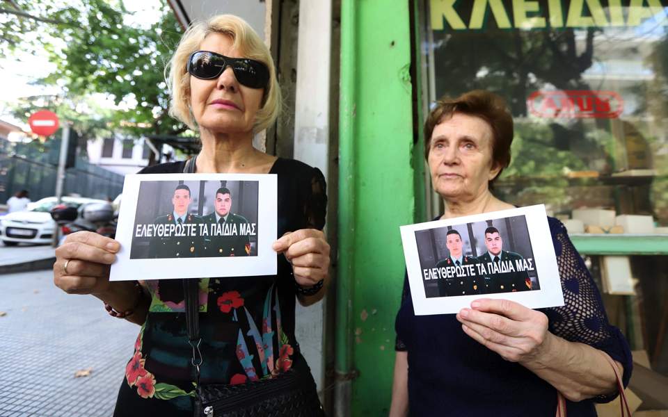 Greek mothers carry photos of Greek soldiers