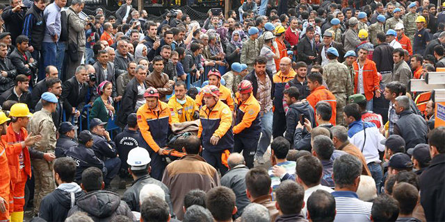 Officials bring a dead body of a miner in Soma