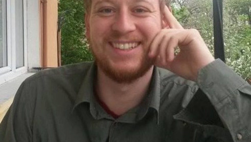 Austrian journalist and student Max Zirngast smiling as he poses for a photograph.