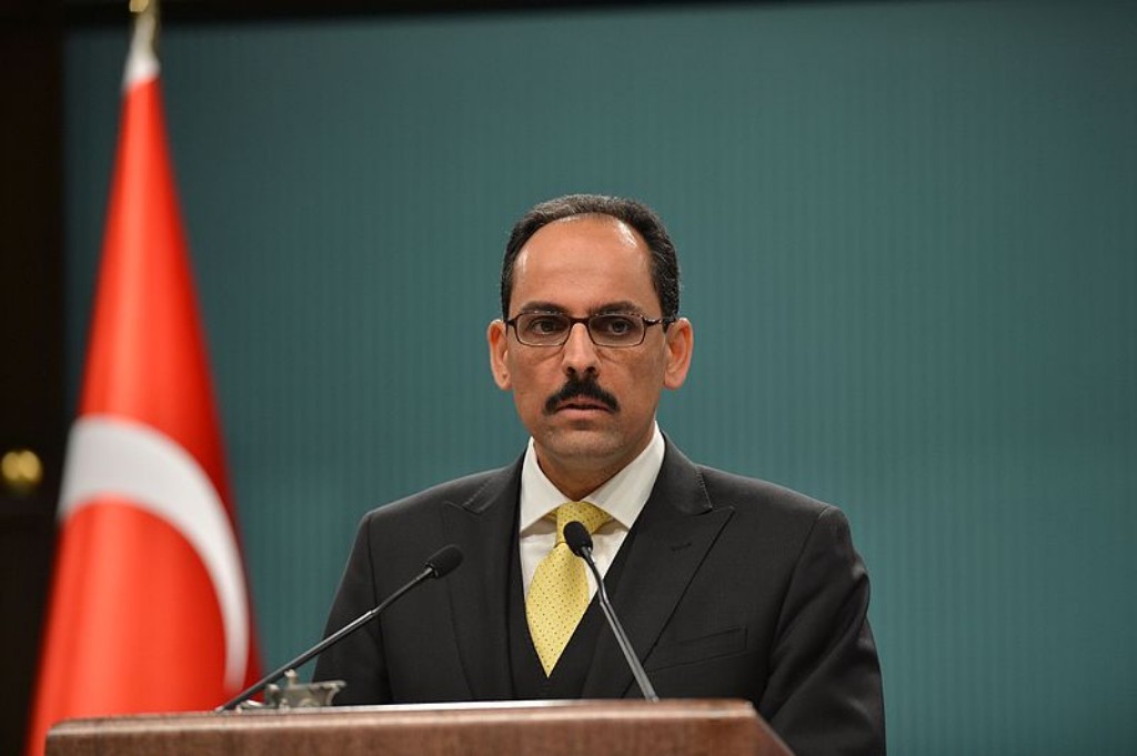 Turkish Presidential Spokesperson Ibrahim Kalin speaking at an event with a Turkish flag next to him in 2015.