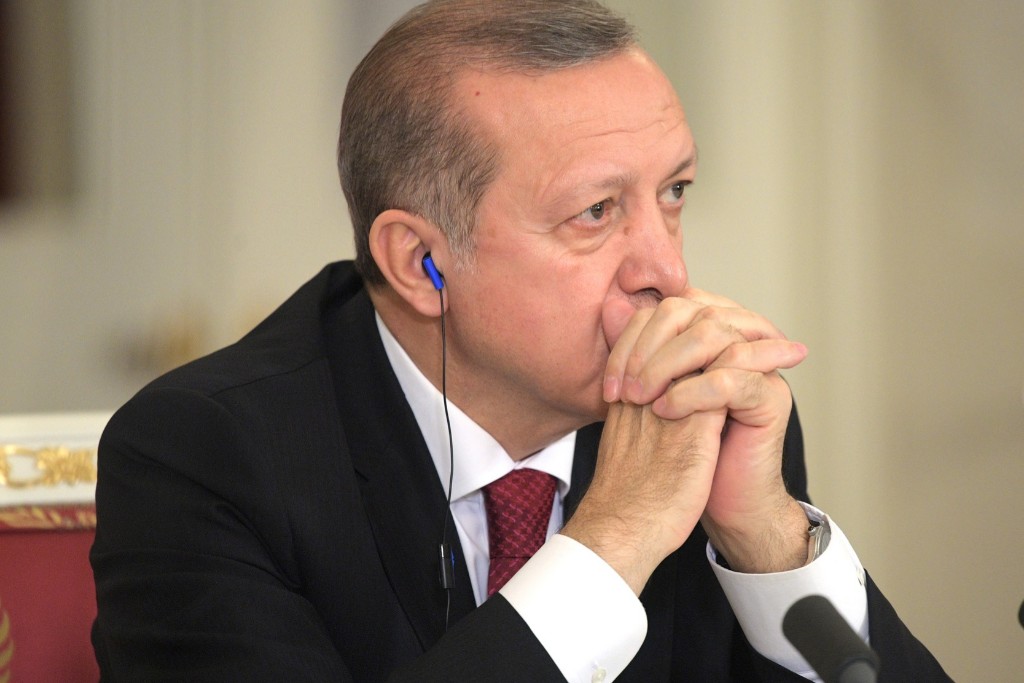 President Recep Tayyip Erdogan listening to a speech with earphones.
